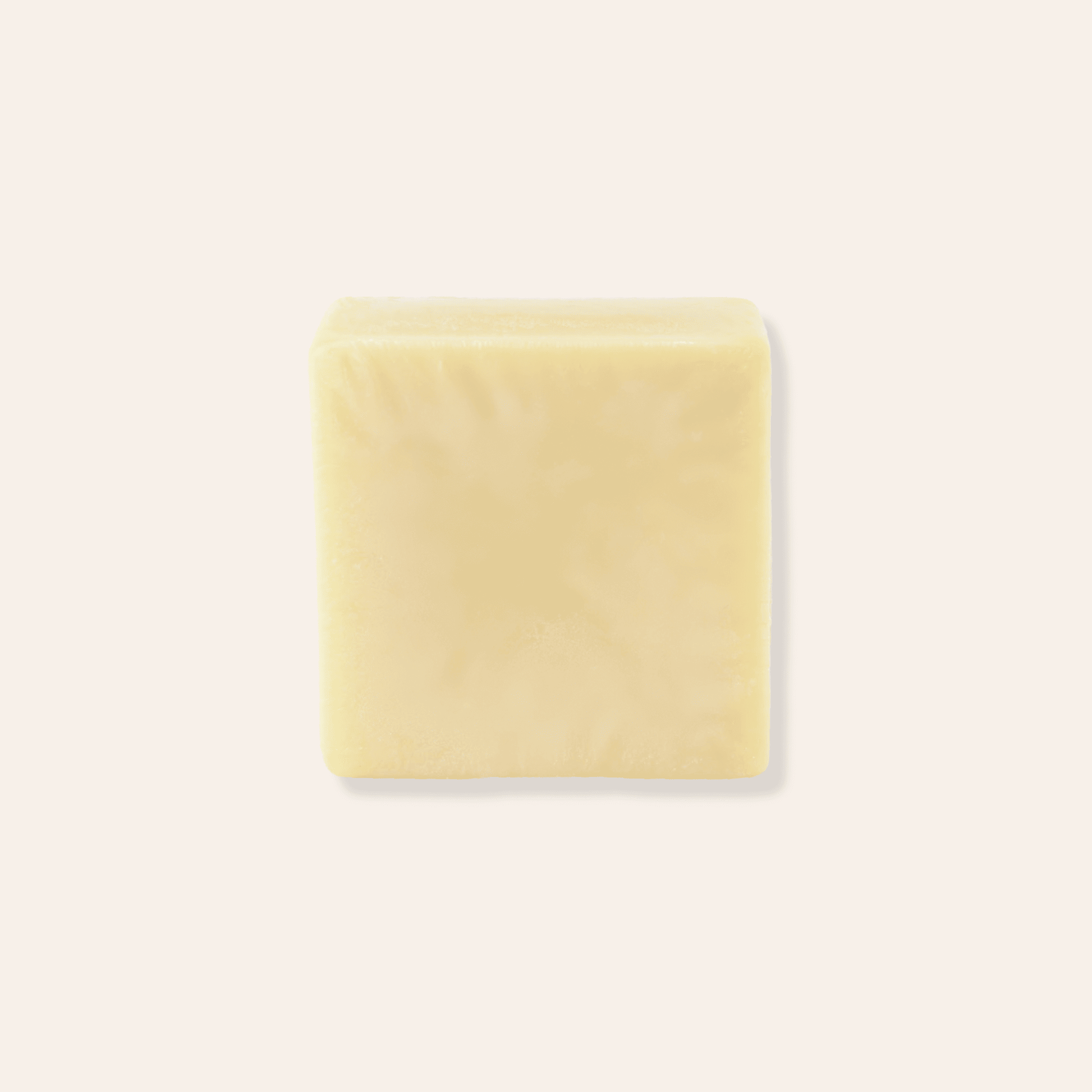 A yellow solid conditioner bar in front of a black box with a kraft label.
