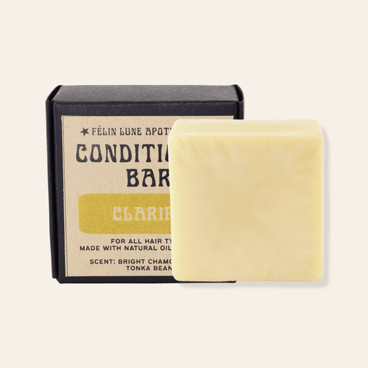 A yellow solid conditioner bar in front of a black box with a kraft label.
