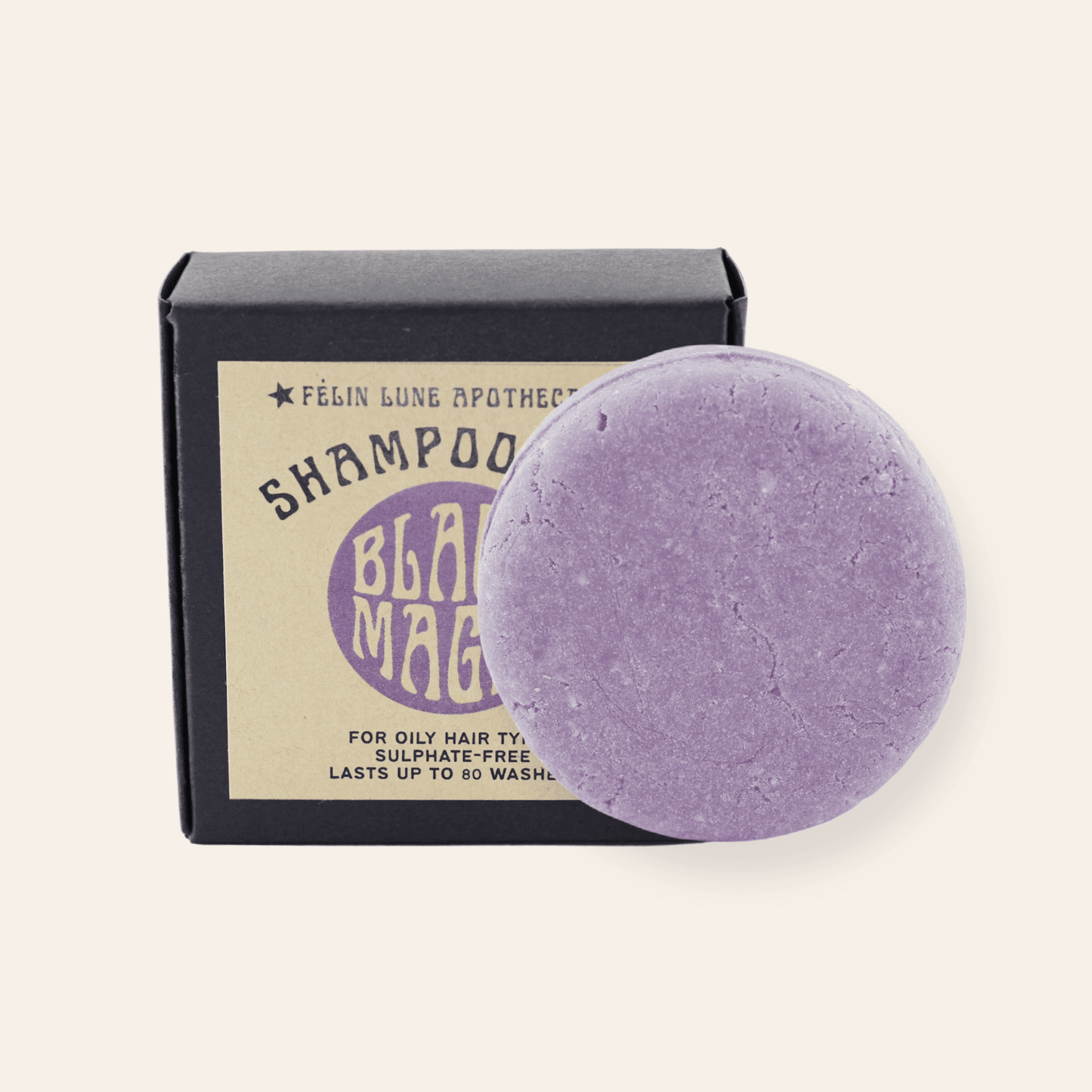 A round purple shampoo bar set in front of a black box and kraft label.
